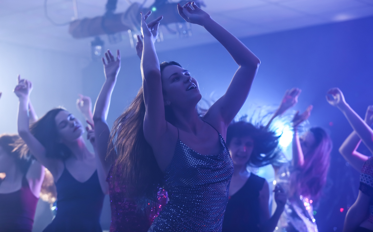 Beautiful young women dancing in night club. (c) AdobeStock