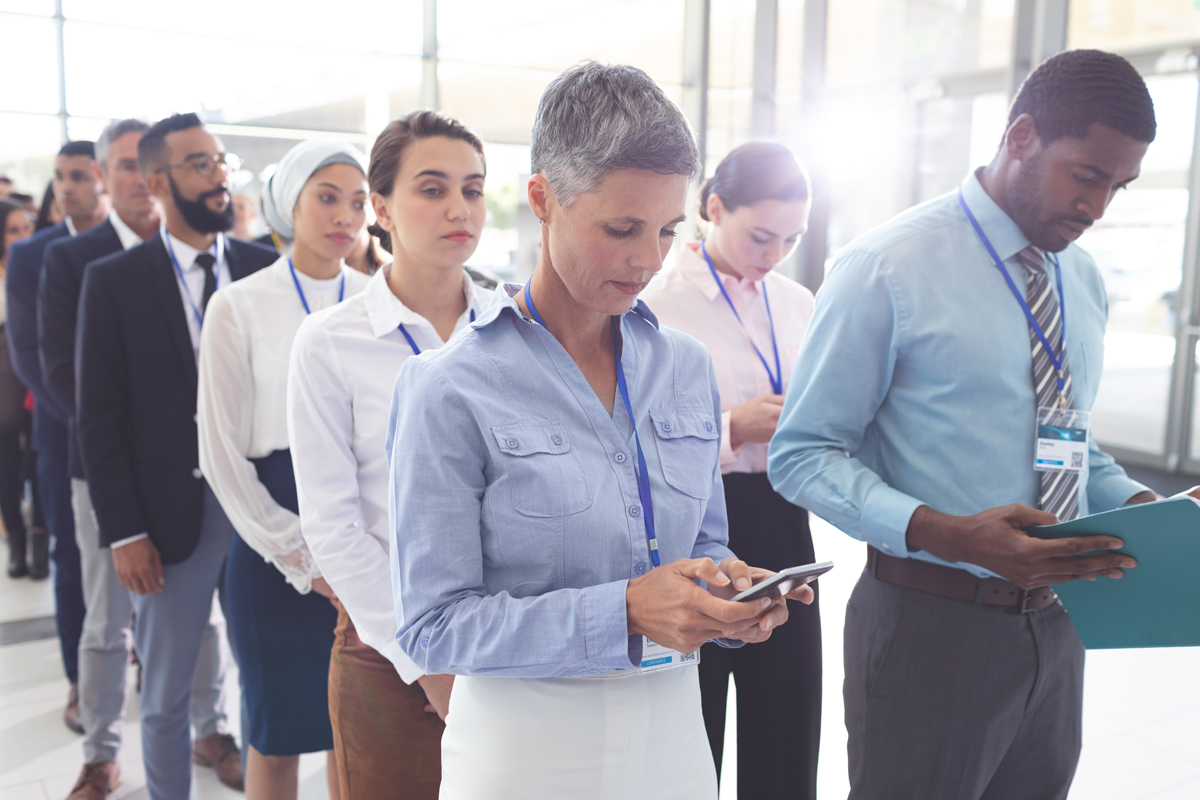 Business people standing in queue in lobby. (c) AdobeStock