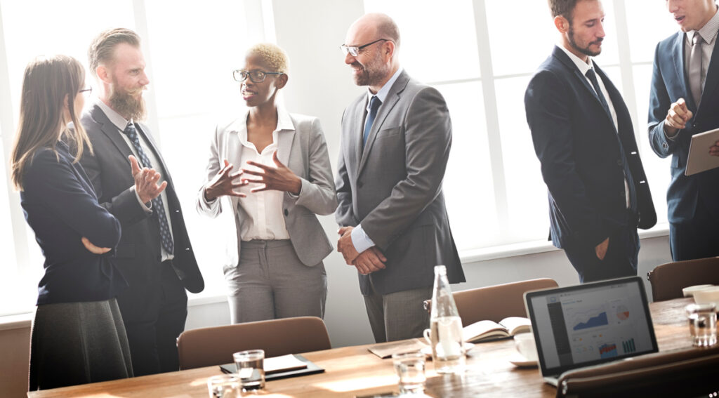 Geschäftsleute im Gespräch vor einem Meeting, Stichwort Anglizismen.
(c) AdobeStock