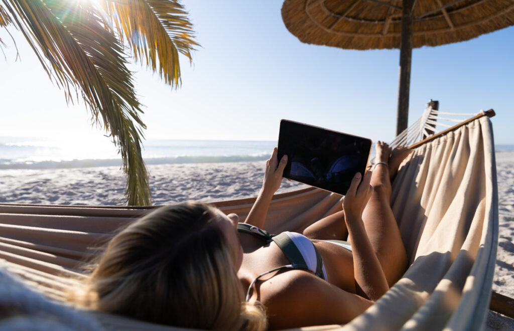 Eine Frau in der Hängematte beim Lesen auf einem iPad, Stichwort KI an der Börse.
(c) AdobeStock