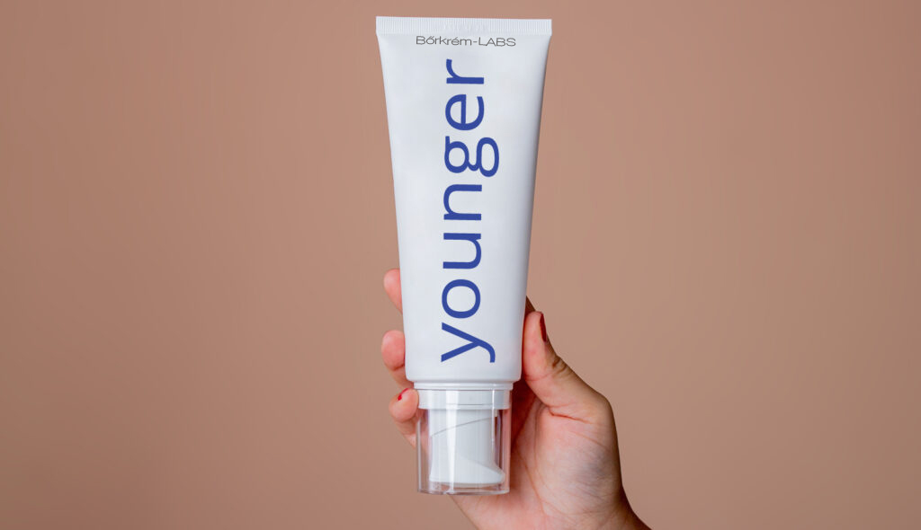 Die Hand einer Frau, die eine Tube "Younger" hält, Stichwort Hautcreme.
(c) AdobeStock