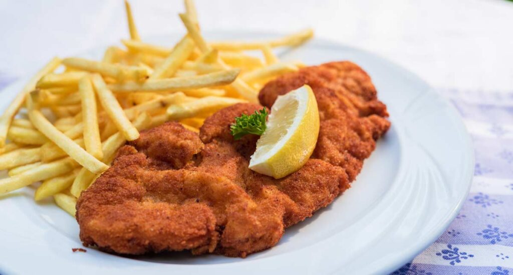 Ein Teller mit einem Schnitzel mit Pommes, Stichwort Leit-Kultur.
(c) AdobeStock