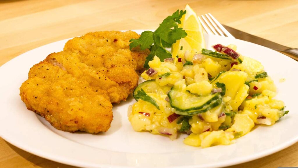 Ein Teller mit einem Schnitzel und Kartoffelsalat, Stichwort Wirtshauspflicht.
(c) Pixabay.com