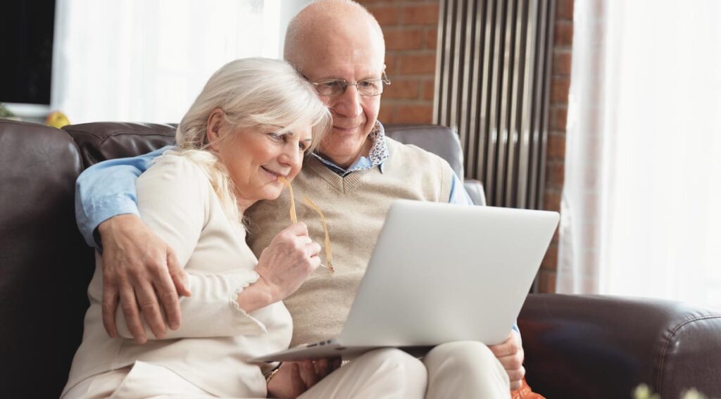 Ein älteres Paar auf einer Couch mit einem Laptop, Sichwort Plakolm.
(c) AdobeStock