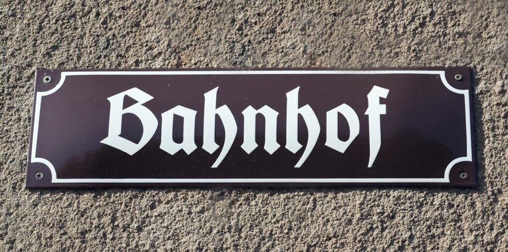 Ein Straßenschild, auf dem "Bahnhof" steht, Stichwort Dialketkurse.
(c) Pixabay.com